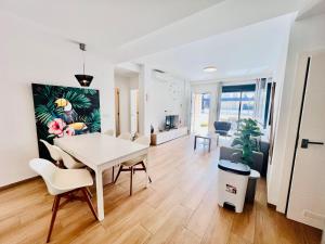 a dining room and living room with a table and chairs at Apto Higuericas playas in Pilar de la Horadada