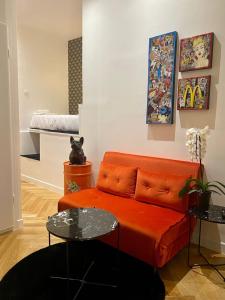 sala de estar con sofá naranja y cama en 206 Suite Hermès - Superb apartment in Paris, en París