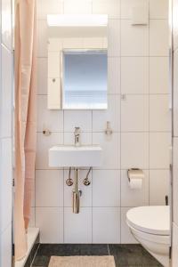 een badkamer met een wastafel en een toilet bij Bijou Sternen - Bergluft und Seeträume in Faulensee