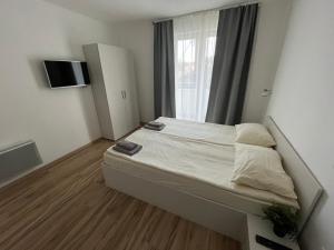 ein kleines Schlafzimmer mit einem Bett mit Fenster in der Unterkunft Milutinn-Visterija in Sokobanja