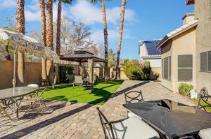a patio with a table and chairs and palm trees at Chic Vegas Retreat: Near Top Attractions in Las Vegas