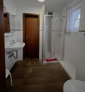 a bathroom with a shower and a sink at Hotel Anka in Norddorf