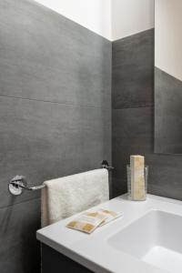 Damatti Appartamento في مسينة: حمام مع حوض أبيض ومنشفة