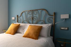 een blauwe slaapkamer met een bed met 2 gele kussens bij Damatti Appartamento in Messina