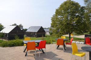 un grupo de sillas y mesas coloridas en un patio en Les lodges de Sainte-Suzanne, en Sainte-Suzanne