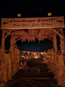 a gate with a sign that reads flamingo camp for just over four people at flamingo camp in Dār as Salām