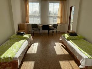 2 Betten in einem Zimmer mit Tisch und Stühlen in der Unterkunft D8 APARTMÁNY in Ústí nad Labem
