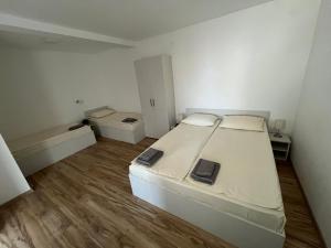 Un dormitorio con una cama grande blanca y suelo de madera. en Milutinn-Jabuka, en Soko Banja 45 fotos más