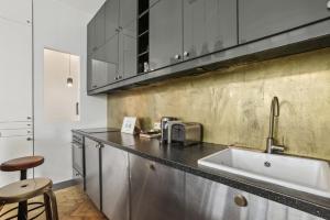 uma cozinha com um lavatório e uma bancada em 142 Suite Ober - Superbe Appartement à Paris em Paris