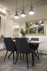 a dining room table with chairs and a mirror at STAY Urban Skin Suite in Nicosia
