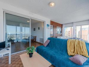 a living room with a blue couch and a table at Apartment Les Cyclades-2 by Interhome in Port Leucate