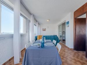 a dining room with a blue table and chairs at Apartment Les Cyclades-2 by Interhome in Port Leucate +23 photos