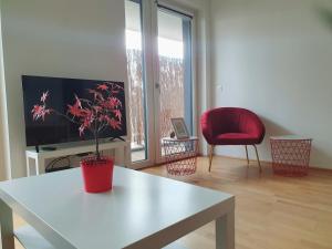 a living room with a table and a red chair at Near Lake One Bedroom Adorable Apartment in Vienna