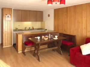 ヴェルビエにあるアパートメント　ボーソレイユ　ヴェルビエのキッチン(木製テーブル、赤いソファ付)