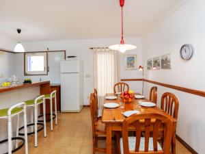 cocina y comedor con mesa de madera y sillas en Holiday Home Delta 1 by Interhome en L'Escala
