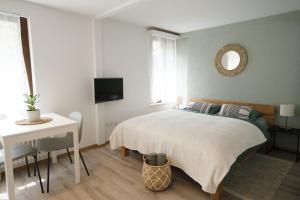 een slaapkamer met een bed, een tafel en een spiegel bij Bijou Studio with Ambiance near Lake in Faulensee