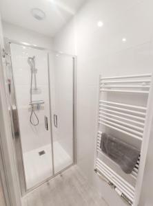 um chuveiro com uma porta de vidro na casa de banho em L’ÉCHO DES VAGUES em Fort-Mahon-Plage