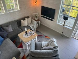 uma sala de estar com um sofá e uma mesa em Alpstigen 6A - 10 bäddars fjällstuga mitt i Järvsöbacken em Järvsö