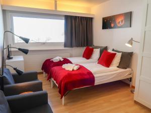 Schlafzimmer mit einem Bett mit roten Kissen und einem Fenster in der Unterkunft Apartment Rosablanche C65 by Interhome in Siviez
