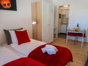 Schlafzimmer mit einem Bett mit einer roten Decke und einem Tisch in der Unterkunft Apartment Rosablanche C65 by Interhome in Siviez