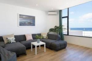 ein Wohnzimmer mit Sofa und Tisch in der Unterkunft Vivienda Vacacional Juanipa in La Santa