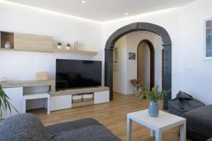 ein Wohnzimmer mit Sofa und Fernseher in der Unterkunft Vivienda Vacacional Juanipa in La Santa