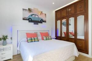 ein Schlafzimmer mit einem Bett mit einem Autobild an der Wand in der Unterkunft Vivienda Vacacional Juanipa in La Santa