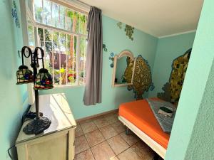 Habitación pequeña con cama y ventana en Hostel Los Duendes del Sur, en Costa del Silencio