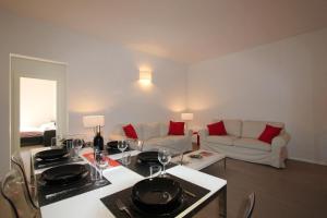 フィレンツェにあるSantAmbrogio Apartmentのリビングルーム(ワイングラス付きのテーブル付)