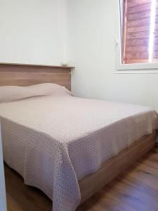 a bed in a white room with a window at Beautiful private house 50m from the sea in Kali