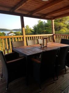 a wooden table and chairs on a wooden deck at Beautiful private house 50m from the sea in Kali