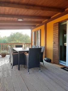 a patio with a table and chairs on a deck at Beautiful private house 50m from the sea in Kali