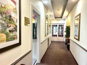 a hallway in a building with paintings on the walls at Logis Hôtel des Messageries in Arbois