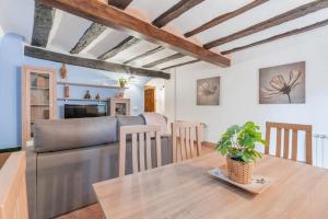 - une cuisine et une salle à manger avec une table et un canapé dans l'établissement CASA RURAL EL GARROTE, à Gea de Albarracín