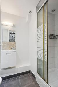 a white bathroom with a sink and a shower at 851 Suite Beautiful Superb Apartment in Asnières-sur-Seine