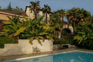 a pool in front of a house with palm trees at Maison Tournesol in Gan