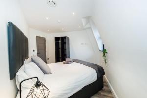 a bedroom with a large bed with white sheets at Two Bedroom Duplex in Liverpool City Centre in Liverpool