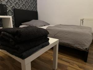 a bedroom with a bed and a pile of blankets at Fair apartment 2 in Kelsterbach