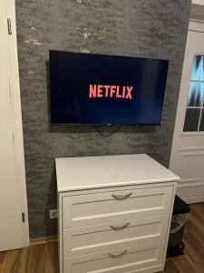 a white dresser with a television on a wall at Fair apartment 2 in Kelsterbach