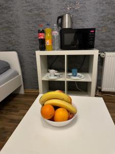 a bowl of oranges and bananas on a table at Fair apartment 2 in Kelsterbach