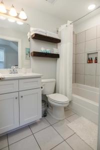 a bathroom with a toilet and a sink and a tub at Lowcountry Lux 5 min to Beach 7 min to Dtwn in Charleston