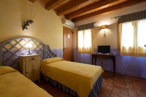 a hotel room with two beds and a television at Rosalimone BeB in Campodarsego