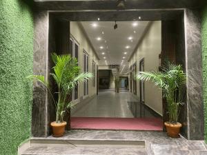 a hallway with potted plants in a building at Hotel Chanduka Palace , Puri in Puri