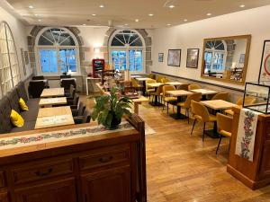 - un restaurant avec des tables et des chaises dans une salle dans l'établissement Logis Hôtel des Messageries, à Arbois