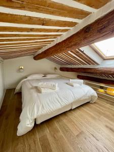 a bedroom with a white bed in a attic at Magnifique appartement + terrasse au cœur d’Aix in Aix-en-Provence