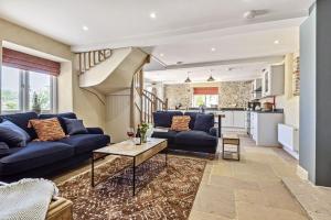 a living room with blue couches and a table at Yawlings in Holditch