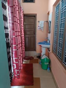 a bathroom with a sink and a toilet and a door at gaurav home stay in Barkot