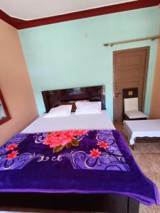 um quarto com uma cama com um cobertor roxo em gaurav home stay em Barkot