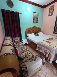 a bedroom with two beds with blankets and pillows at gaurav home stay in Barkot