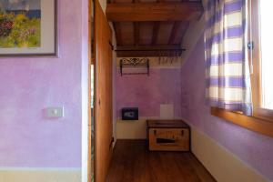 un pasillo con una pared púrpura y una caja en Rosalimone BeB, en Campodarsego